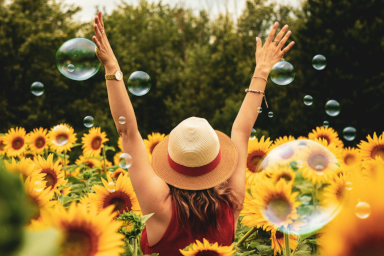 A woman surrounded by sunflowers and bubbles