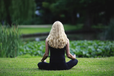 A woman meditating with here legs crossed up on her thights.